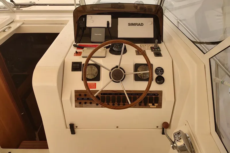 Slide: The Image of 2003 Mainship 34 PILOT helm with steering wheel, gauges, and navigation equipment. - 38