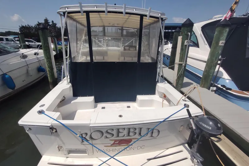 Slide: The Image of 2003 Mainship 34 PILOT boat docked, rear view with "Rosebud" name visible. - 4