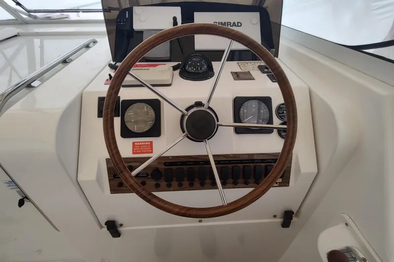 Slide: The Image of 2003 Mainship 34 PILOT helm with steering wheel and navigation instruments. - 43