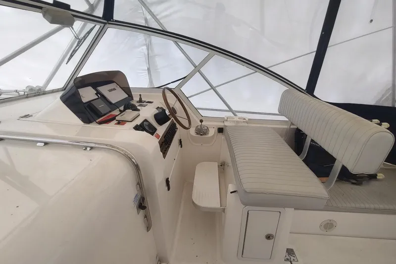 Slide: The Image of 2003 Mainship 34 PILOT helm with steering wheel, navigation equipment, and cushioned seating. - 51