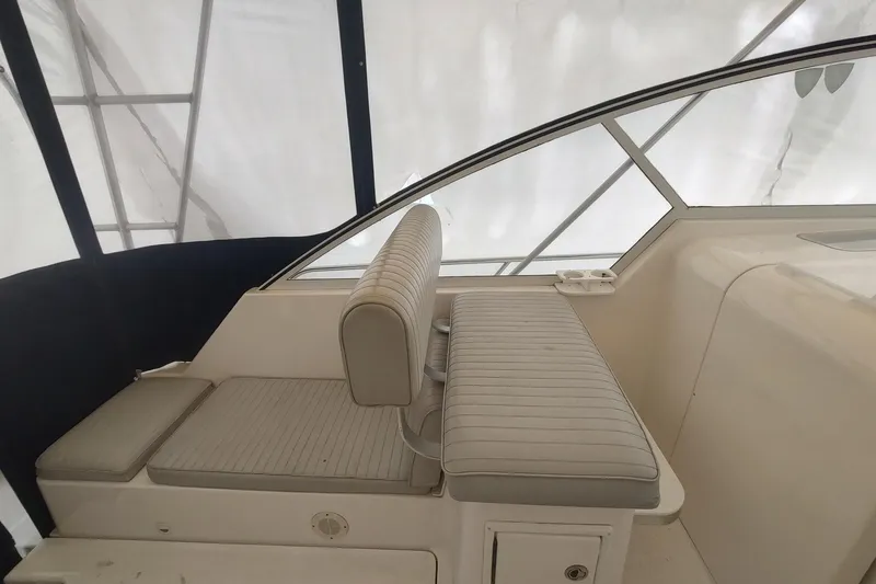 Slide: The Image of 2003 Mainship 34 PILOT interior seating with striped upholstery and window view. - 55