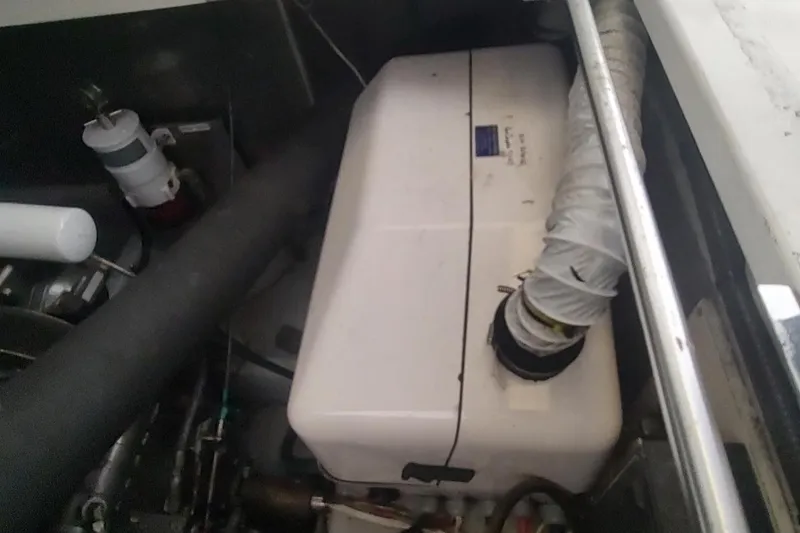 Slide: The Image of Engine compartment of a 2003 Mainship 34 PILOT boat, featuring hoses and components. - 66