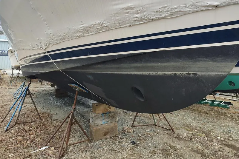 Slide: The Image of 2003 Mainship 34 PILOT boat on stands, partially covered, showing hull details. - 72