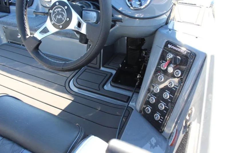 Slide: The Image of Interior of 2026 Phoenix 921 ELITE boat, featuring steering wheel and control panel. - 16