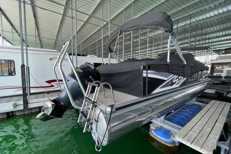 Slide: The Image of 2014 Premier Yachts 250 S-Series RF pontoon boat docked under a covered marina. - 2