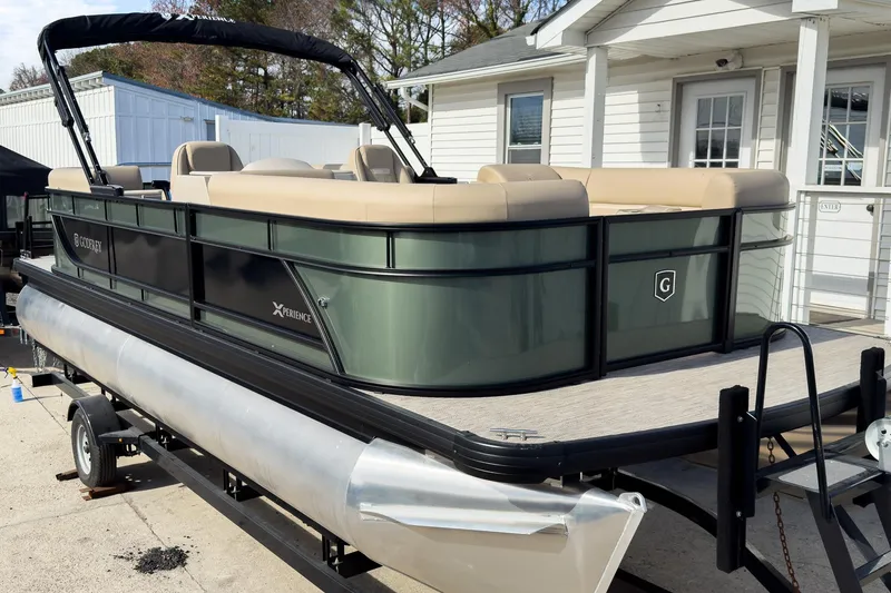 Slide: The Image of 2026 Godfrey Sweetwater Xperience 22' Split Bench Pontoon on trailer, beige seating, outdoor setting. - 4