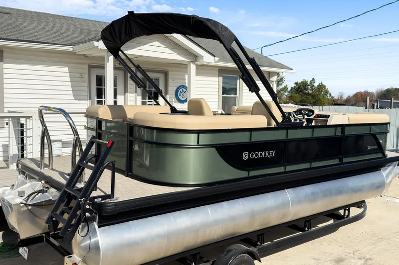 Slide: The Image of 2026 Godfrey Sweetwater Xperience 22' Split Bench Pontoon on trailer, parked near a house. - 6