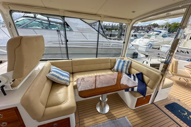 Slide: The Image of Luxurious 2017 MJM 50z yacht interior with beige seating, wooden table, and striped cushions. - 15