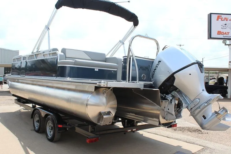 Slide: The Image of 2026 Avalon LSZ Cruiser Rear Bench 23 pontoon boat with Honda outboard motor on trailer. - 2