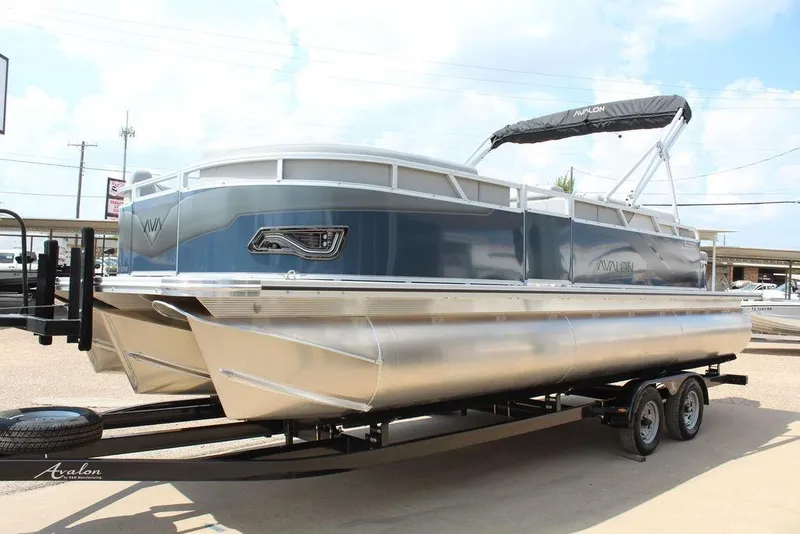 Slide: The Image of 2026 Avalon LSZ Cruiser Rear Bench 23 pontoon boat on trailer, side view. - 3