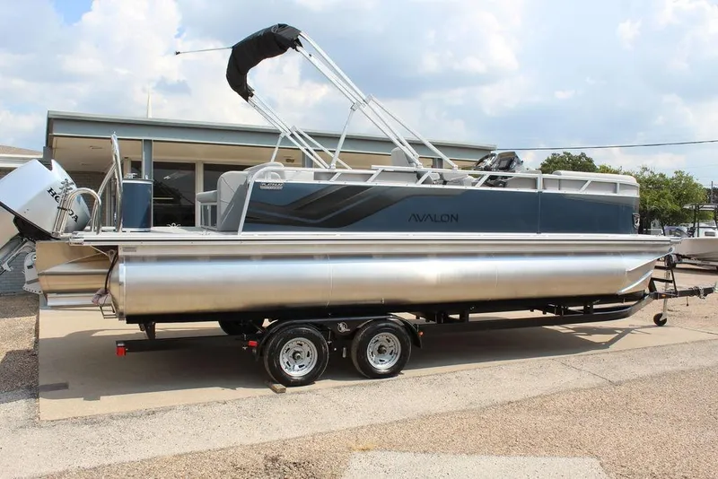 Slide: The Image of 2026 Avalon LSZ Cruiser Rear Bench 23 pontoon boat on trailer, side view. - 4