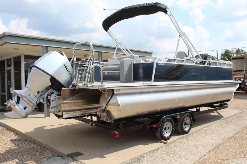 Slide: The Image of 2026 Avalon LSZ Cruiser Rear Bench 23 pontoon boat with Honda outboard motor on trailer. - 8