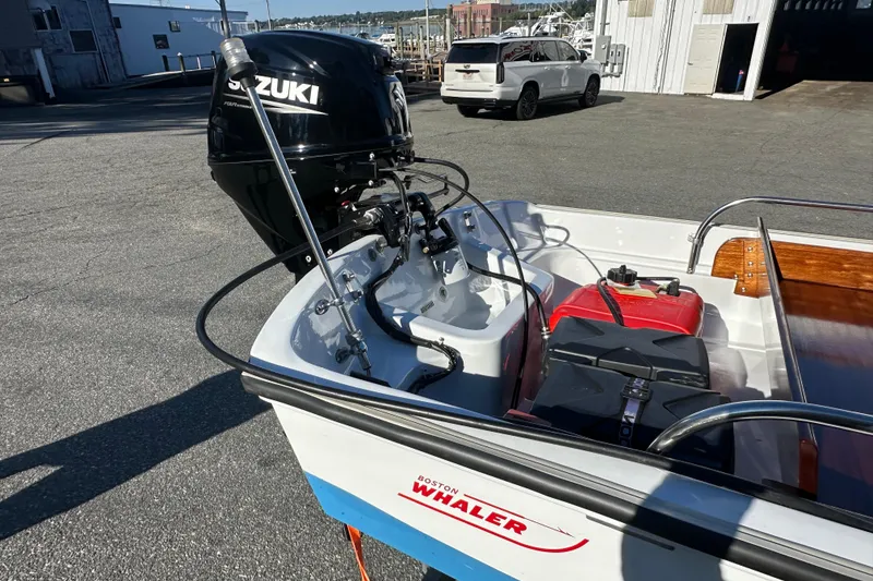 Slide: The Image of 1972 Boston Whaler 13 Super Sport with Suzuki outboard motor, parked near a marina. - 5