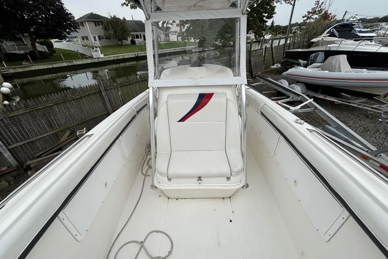 Slide: The Image of 1999 Wellcraft 302 Scarab Sport boat interior with white seating and red-blue accents. - 10