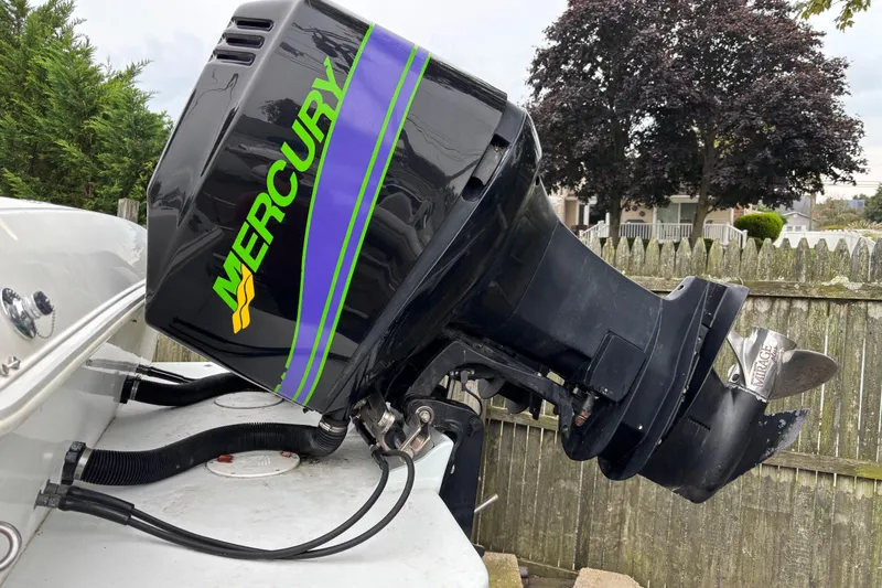 Slide: The Image of Outboard motor on 1999 Wellcraft 302 Scarab Sport boat, featuring Mercury branding. - 3