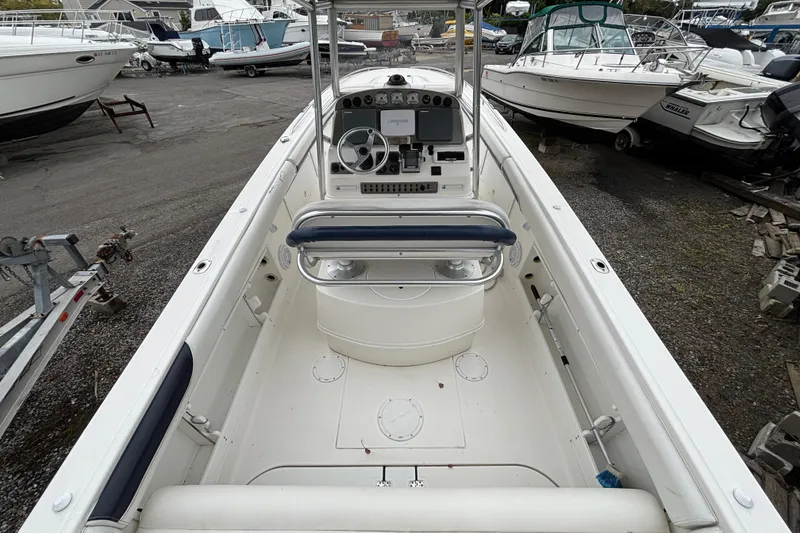 Slide: The Image of 1999 Wellcraft 302 Scarab Sport boat interior, featuring helm and seating, docked among other boats. - 6