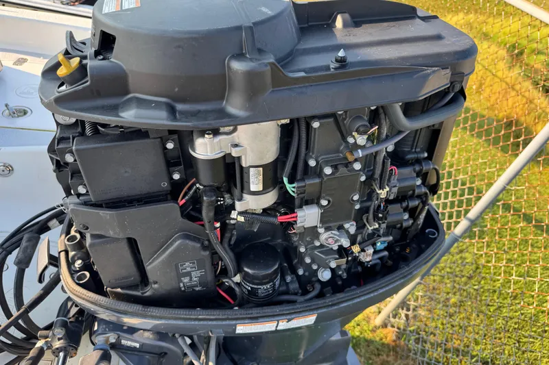 Slide: The Image of Close-up of a 2012 Carolina Skiff 238 DLV boat engine, showcasing intricate components. - 12