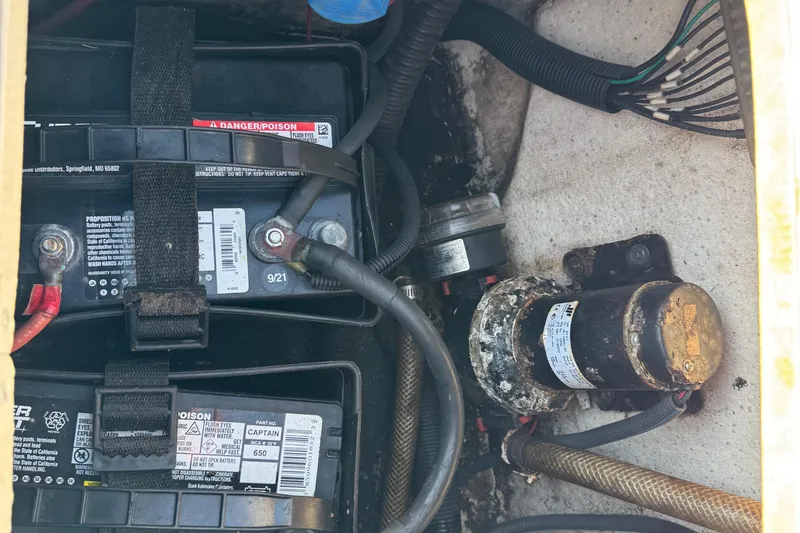 Slide: The Image of Battery compartment of a 2012 Carolina Skiff 238 DLV boat, showing wiring and components. - 18