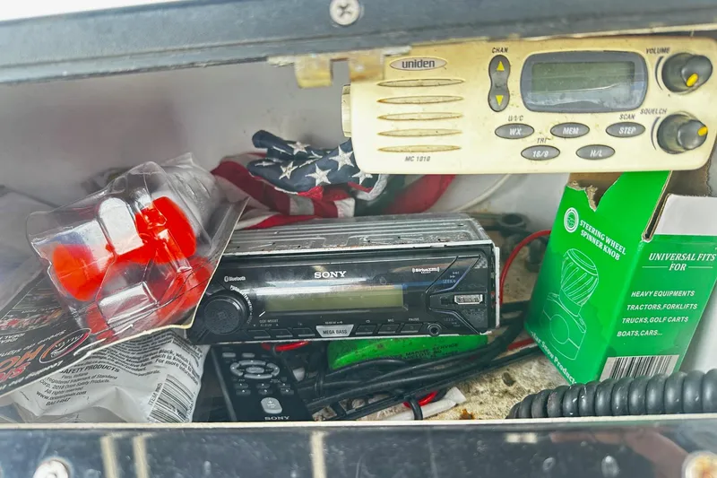 Slide: The Image of Storage compartment in a 1998 Angler 22 Center Console with radio and accessories. - 8