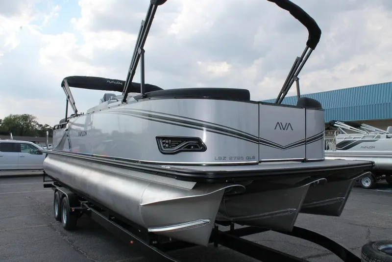 Slide: The Image of 2026 Avalon LSZ QUAD LOUNGER SHIFT pontoon boat on trailer, sleek design, outdoor setting. - 16