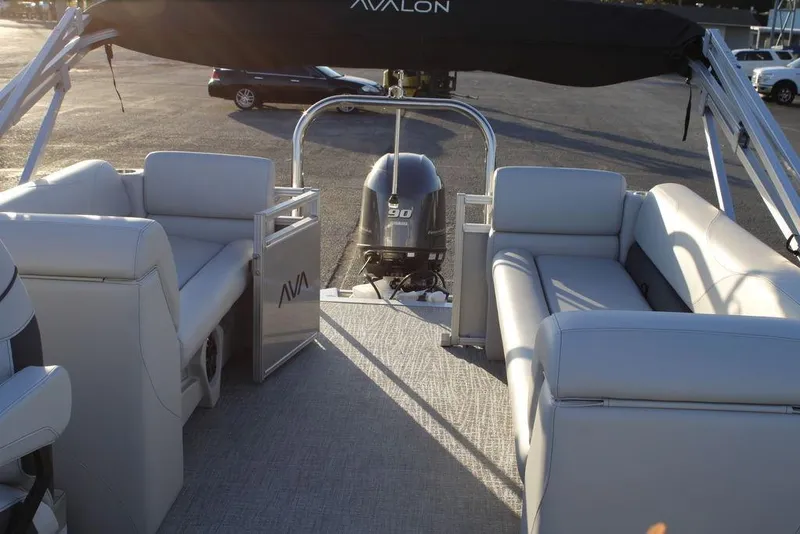 Slide: The Image of 2026 Avalon VLS QUAD LOUNGER 21 pontoon boat interior with seating and motor. - 30