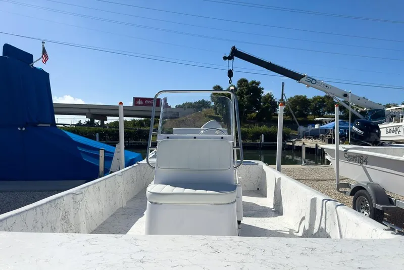 Slide: The Image of 2026 Coastal Skiff 171 boat docked at marina under clear blue sky. - 8
