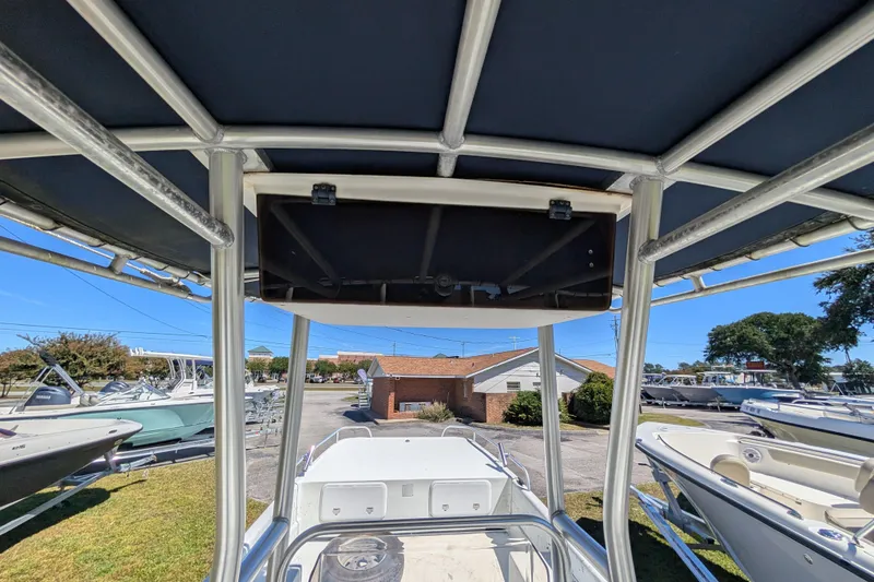 Slide: The Image of 2006 Carolina Skiff 2180 DLX boat with T-top, parked outdoors in a marina. - 12