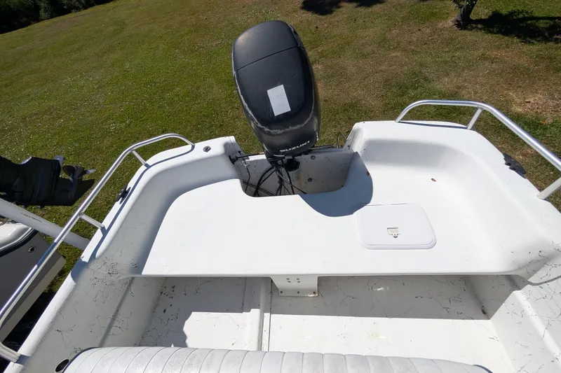 Slide: The Image of 2006 Carolina Skiff 2180 DLX boat with outboard motor on grassy area. - 14