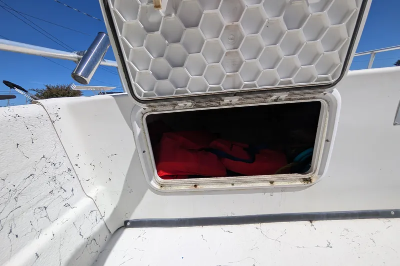 Slide: The Image of Open storage compartment on 2006 Carolina Skiff 2180 DLX boat with life jackets inside. - 5