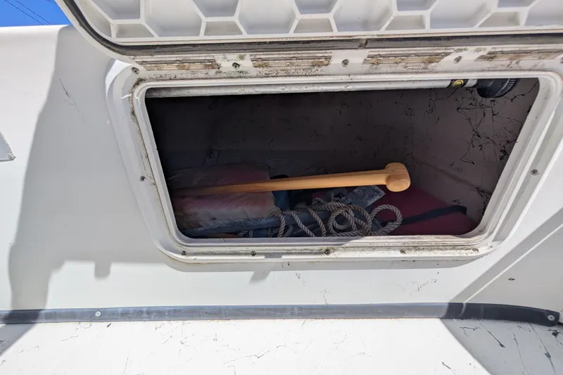 Slide: The Image of Open storage compartment on a 2006 Carolina Skiff 2180 DLX boat, containing ropes and equipment. - 6