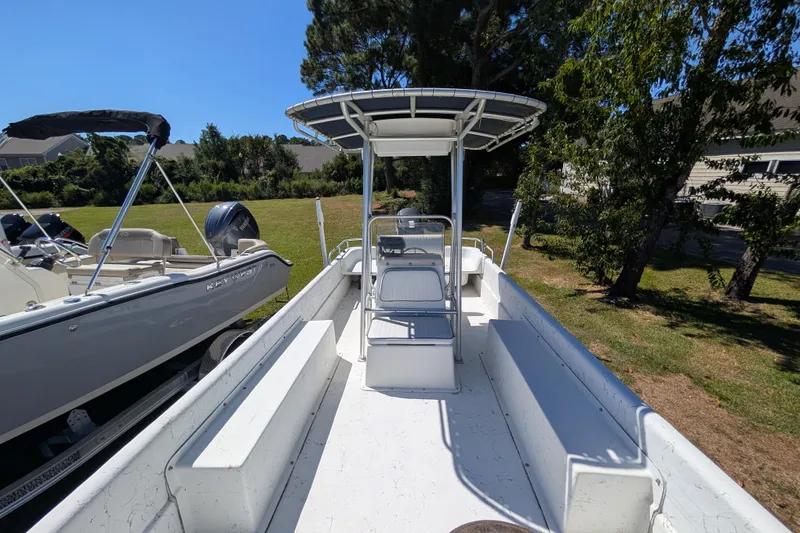 Slide: The Image of 2006 Carolina Skiff 2180 DLX boat with seating and canopy, parked outdoors. - 7
