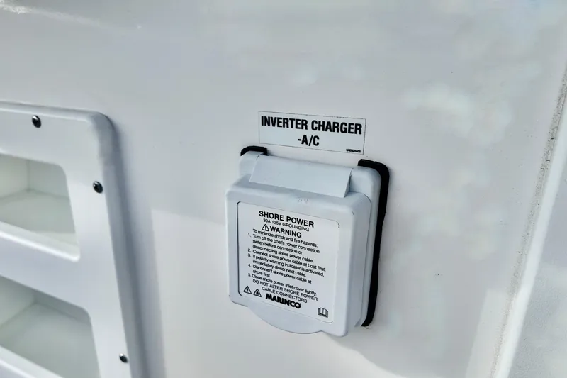 Slide: The Image of Inverter charger on 2026 Sea Fox 328 Commander boat, labeled for A/C shore power connection. - 15