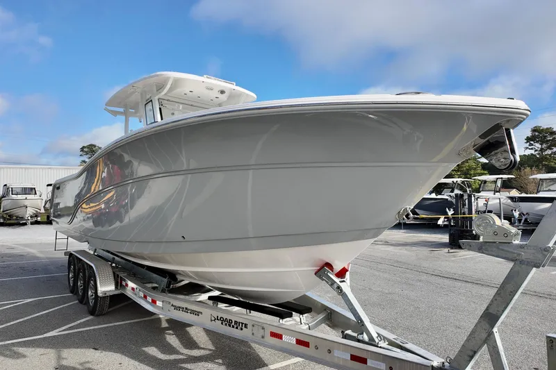 Slide: The Image of 2026 Sea Fox 328 Commander boat on trailer, parked outdoors under blue sky. - 2