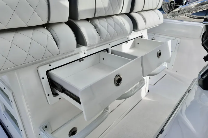 Slide: The Image of 2026 Sea Fox 328 Commander boat interior with open storage drawers and cushioned seating. - 28