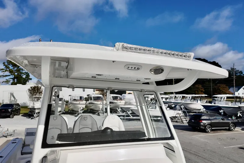 Slide: The Image of 2026 Sea Fox 328 Commander boat with T-top and LED lights in a marina setting. - 5