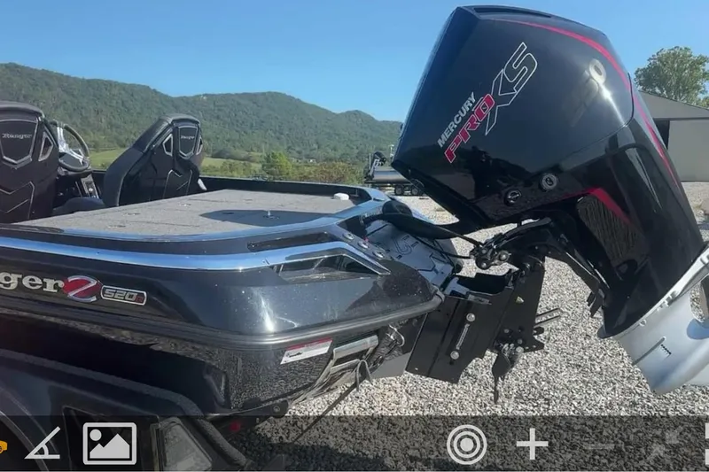 Slide: The Image of 2024 Ranger Z520R boat with Mercury Pro XS engine, parked on gravel with scenic mountain backdrop. - 8
