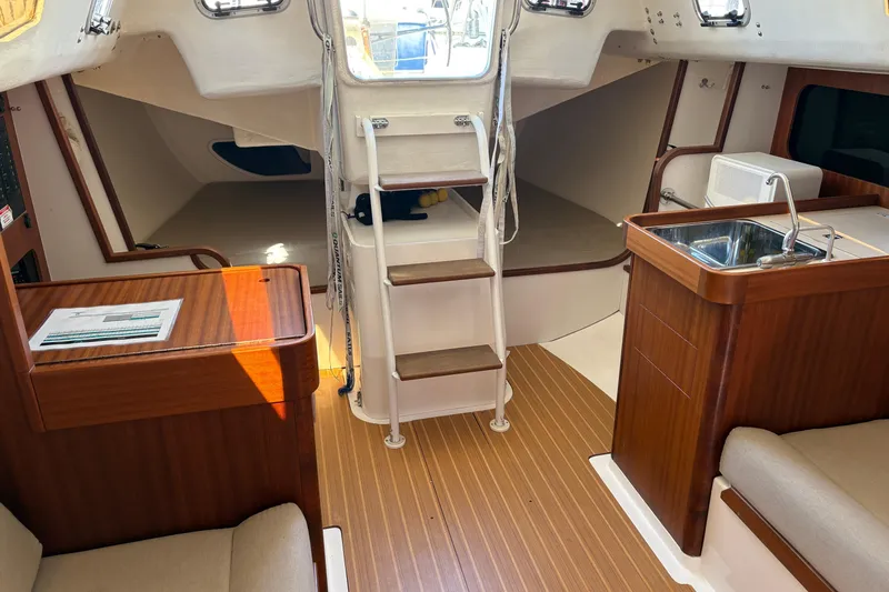 Slide: The Image of Interior of 2014 J Boats J/111 sailboat with wood finish and compact kitchen area. - 15