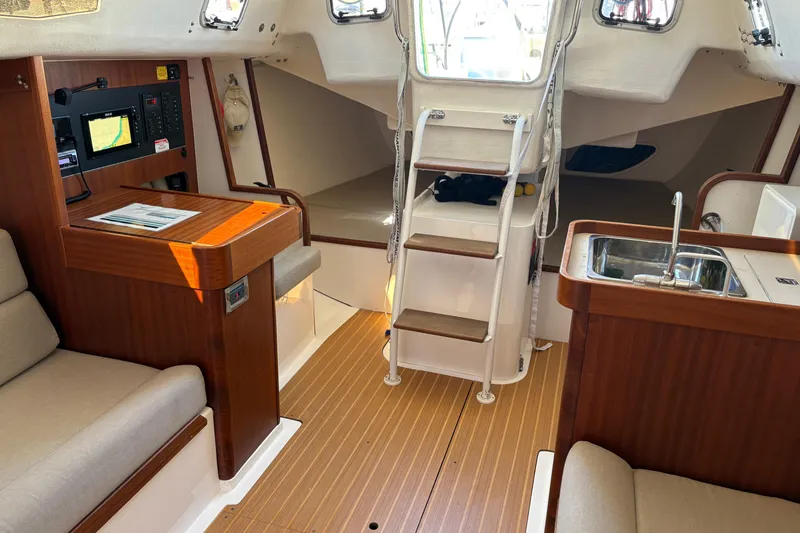 Slide: The Image of Interior of 2014 J Boats J/111 sailboat with wood finish and compact kitchen area. - 16