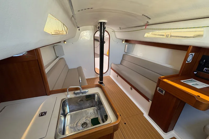 Slide: The Image of Interior of 2014 J Boats J/111 sailboat with seating, sink, and wooden accents. - 18