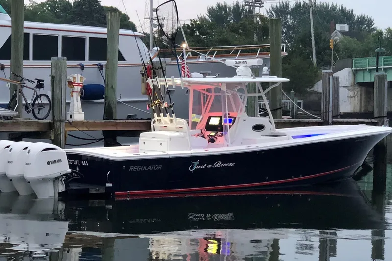 Slide: The Image of 2018 Regulator 34SS boat docked, featuring Yamaha engines and fishing equipment. - 1