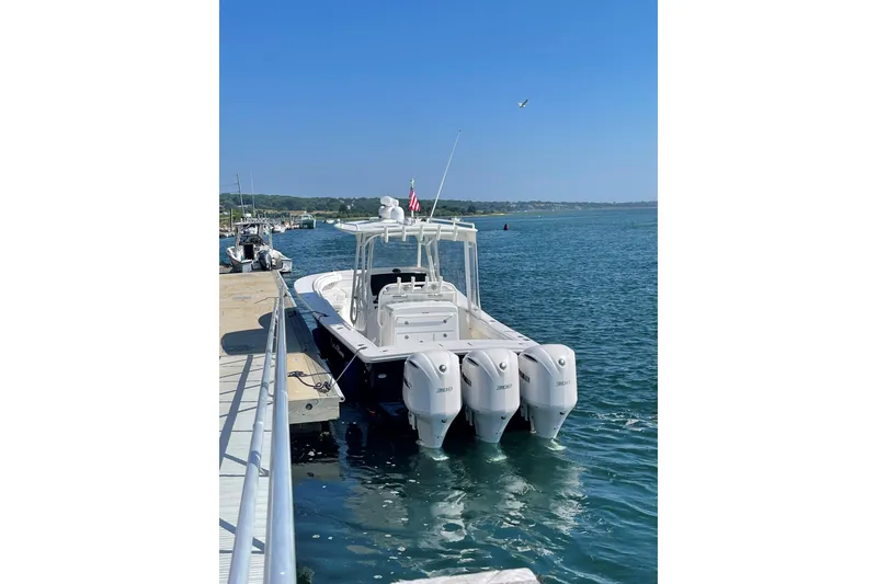 Slide: The Image of 2018 Regulator 34SS boat docked with triple outboard engines on a sunny day. - 2