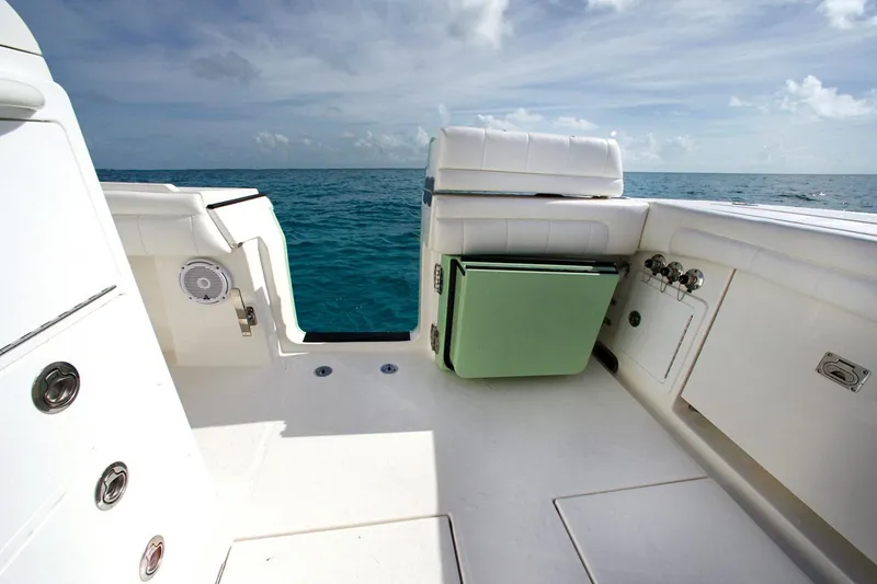 Slide: The Image of 2018 Regulator 34SS boat interior with ocean view, featuring white seating and storage compartments. - 8