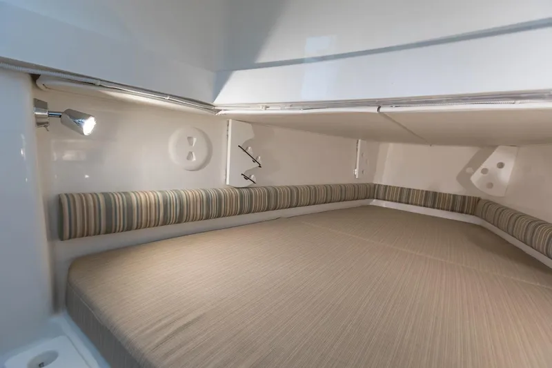 Slide: The Image of 2018 Regulator 34SS cabin interior with striped cushions and overhead lighting. - 9