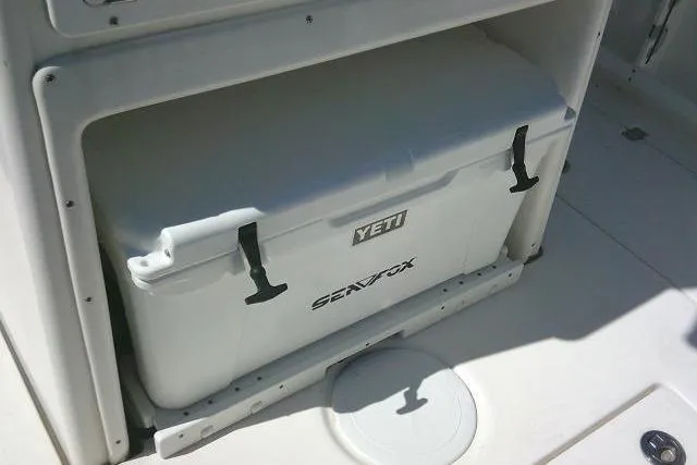 Slide: The Image of YETI cooler on 2021 Sea Fox 288 Commander boat, securely stored in compartment. - 52