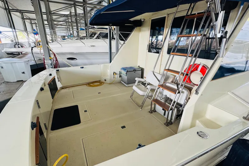 Slide: The Image of 1987 Tollycraft 40 Sport Sedan boat interior with seating and ladder in marina. - 12