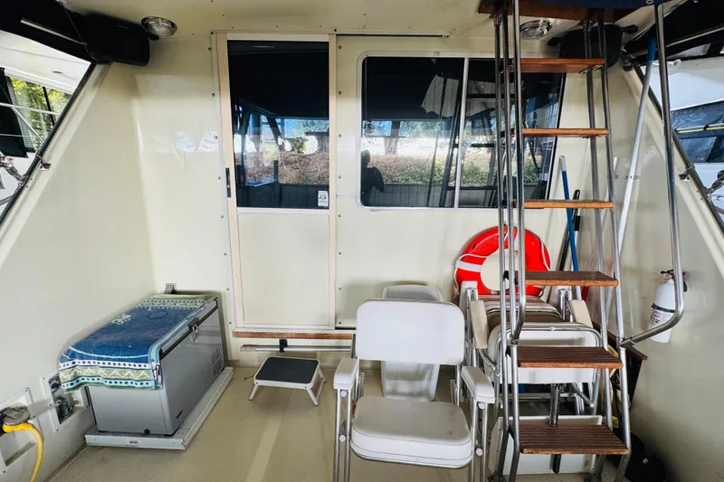 Slide: The Image of 1987 Tollycraft 40 Sport Sedan interior with chairs, ladder, and life preserver. - 13