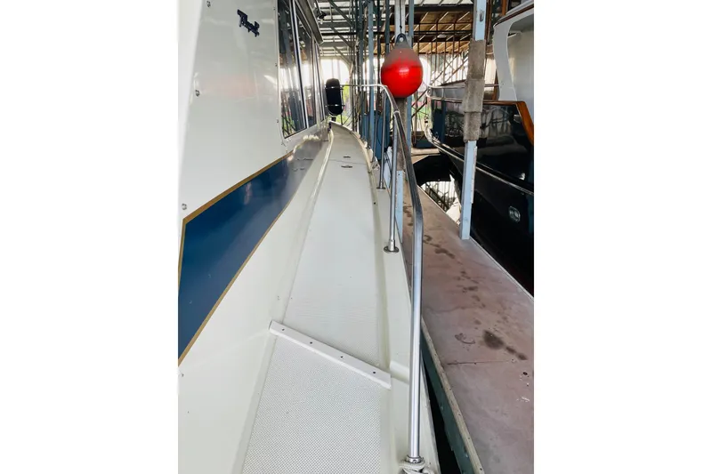 Slide: The Image of 1987 Tollycraft 40 Sport Sedan boat docked in marina, side view with railing. - 15