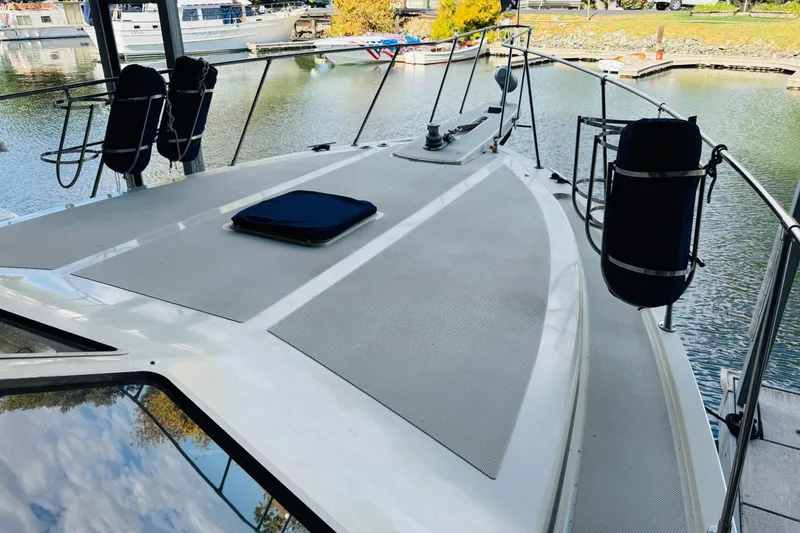 Slide: The Image of 1987 Tollycraft 40 Sport Sedan yacht docked at a marina, showcasing its spacious deck. - 16