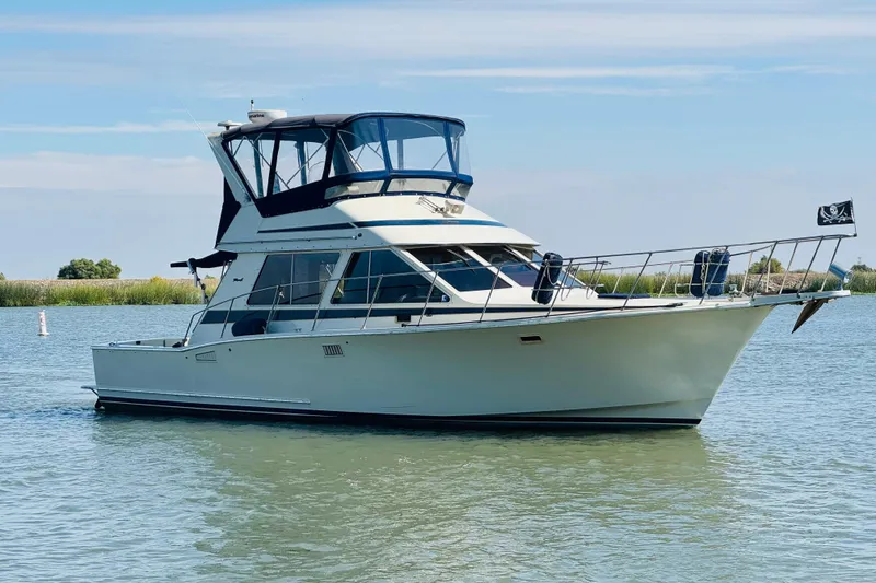 Slide: The Image of 1987 Tollycraft 40 Sport Sedan yacht on calm water, clear sky background. - 2