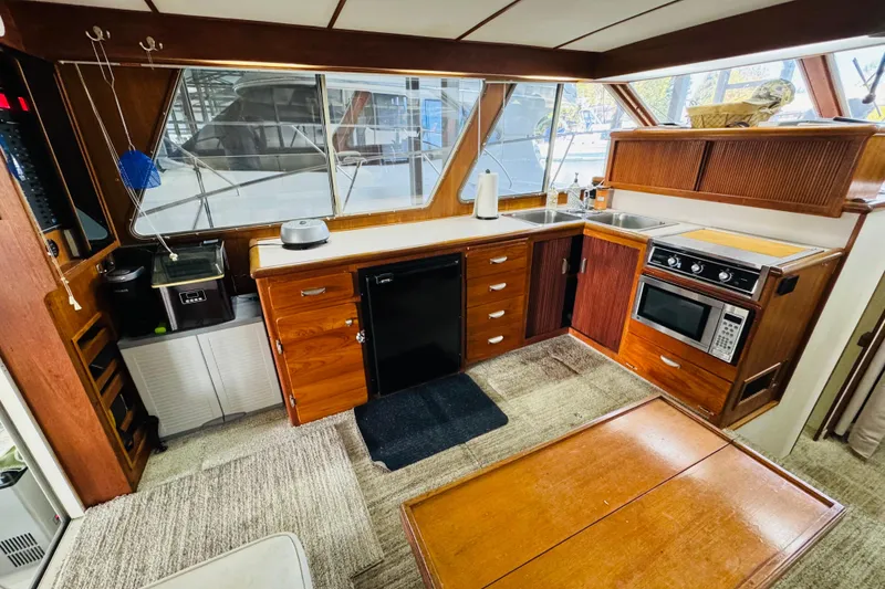 Slide: The Image of Interior of 1987 Tollycraft 40 Sport Sedan with wooden cabinetry and modern appliances. - 31